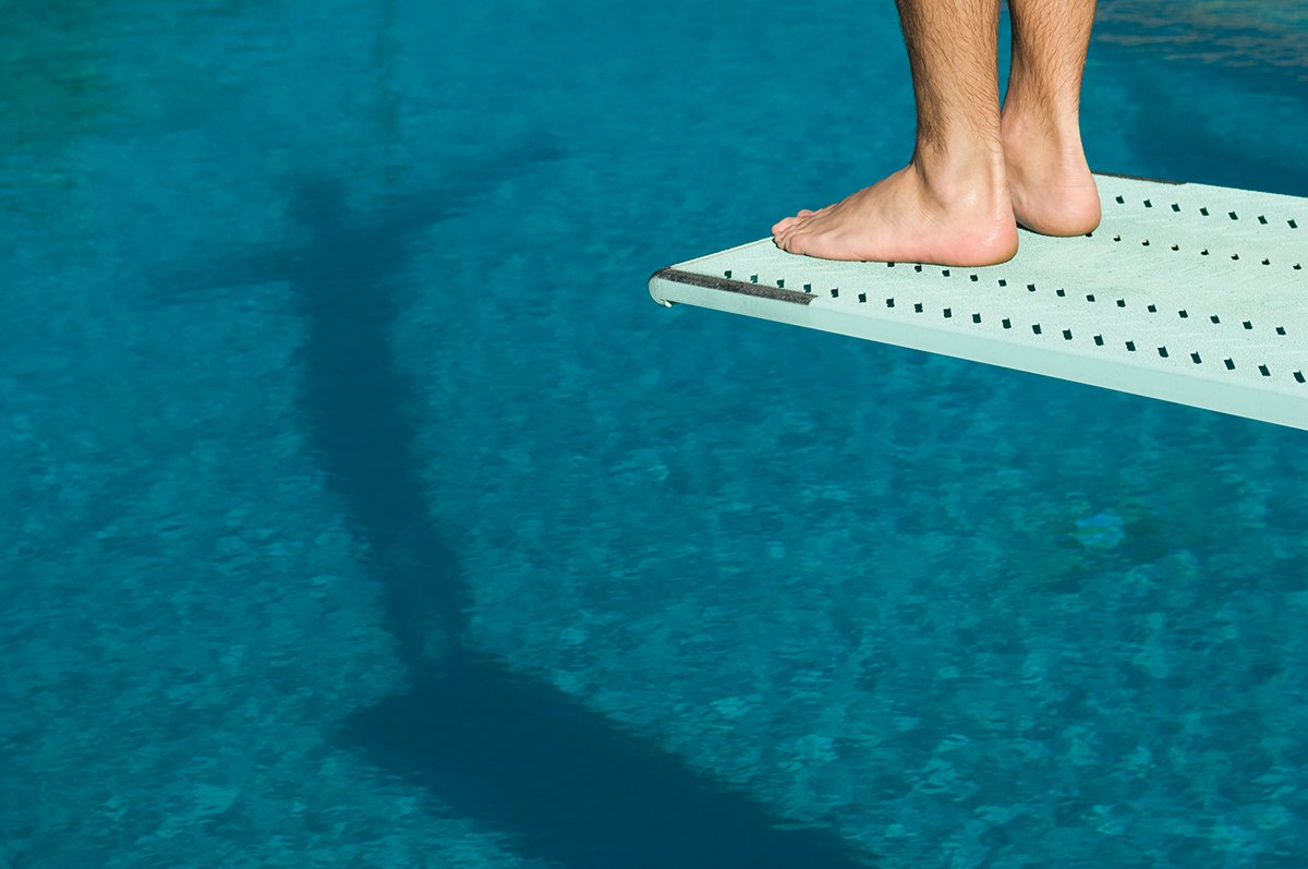 Male swimmer standing on diving board