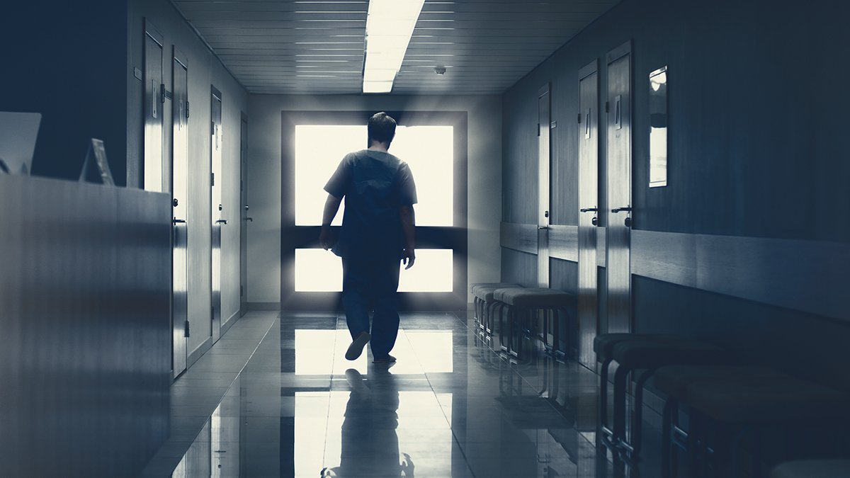 In the Hospital Elderly Pensioner Man Walks down the Hallway with Light in the End. Clean Modern Medical Facility. Life after Death, Door to Heaven Concept.